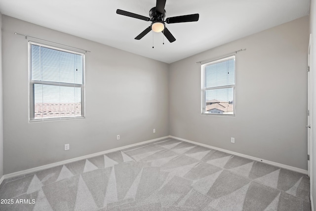 empty room with baseboards, light carpet, and a ceiling fan