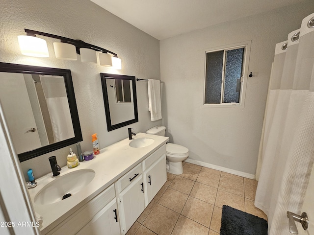 full bathroom featuring double vanity, a sink, toilet, and tile patterned floors