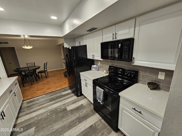 kitchen with visible vents, decorative backsplash, light wood-style floors, black appliances, and white cabinetry