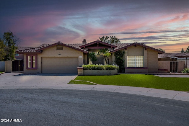 view of front of home with a yard and a garage