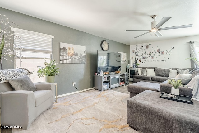 living room featuring baseboards, ceiling fan, and wood finished floors