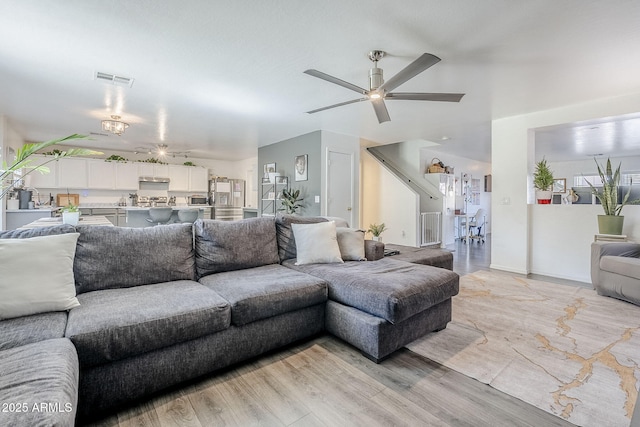 living area with a ceiling fan, visible vents, and light wood-style flooring
