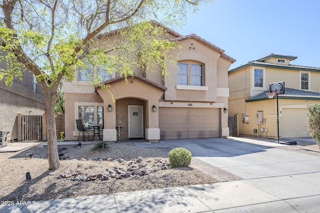 mediterranean / spanish-style house with concrete driveway, an attached garage, fence, and stucco siding