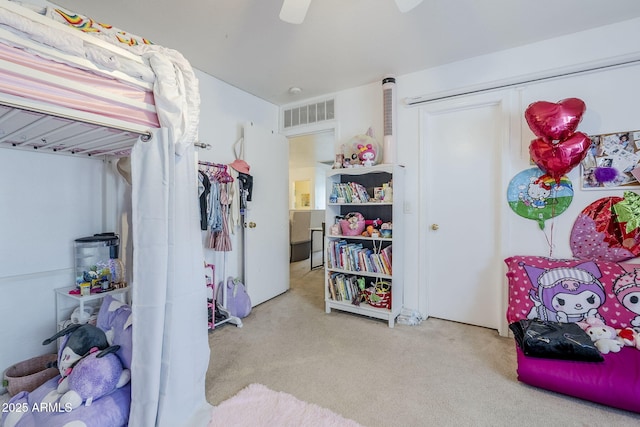 carpeted bedroom featuring ceiling fan, visible vents, and a closet