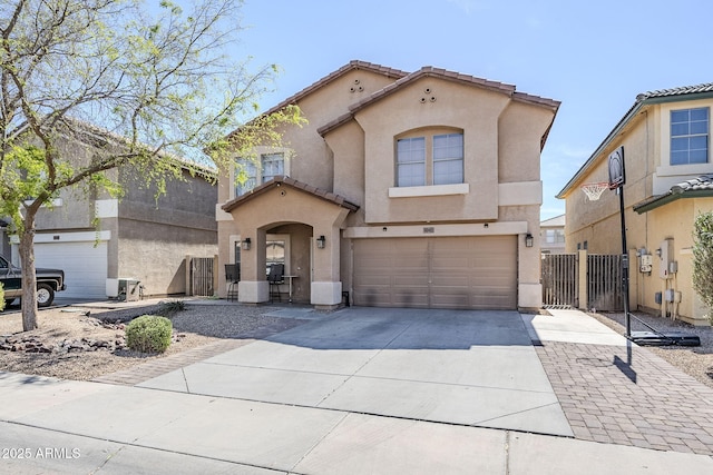 mediterranean / spanish house with a tiled roof, a garage, fence, concrete driveway, and stucco siding