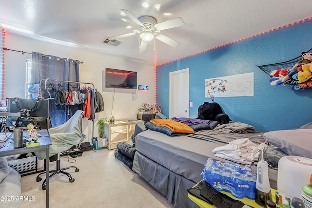 bedroom with visible vents, a ceiling fan, and a textured wall