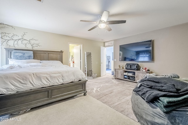 bedroom featuring light colored carpet, a ceiling fan, and connected bathroom