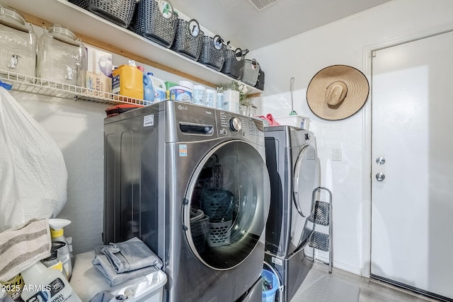 clothes washing area featuring washer and dryer and laundry area