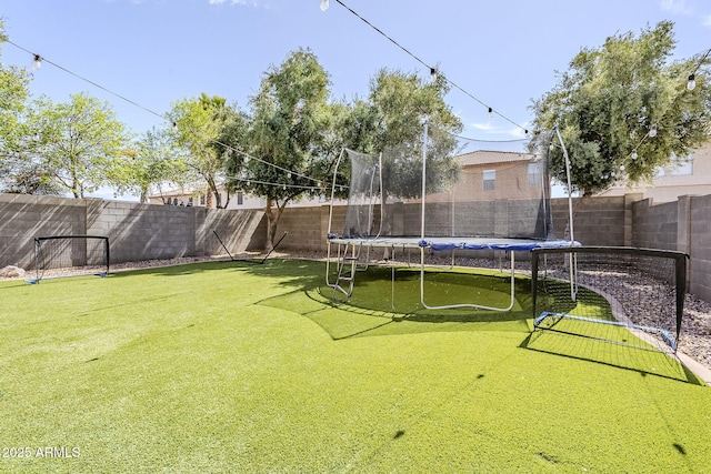 view of yard with a fenced backyard and a trampoline