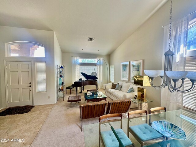 carpeted living room with lofted ceiling and a chandelier