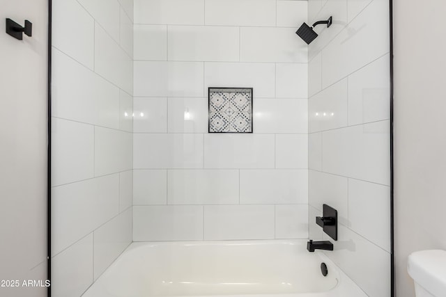 bathroom featuring tub / shower combination and toilet