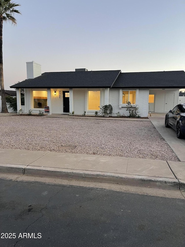 view of front of property with concrete driveway and a chimney