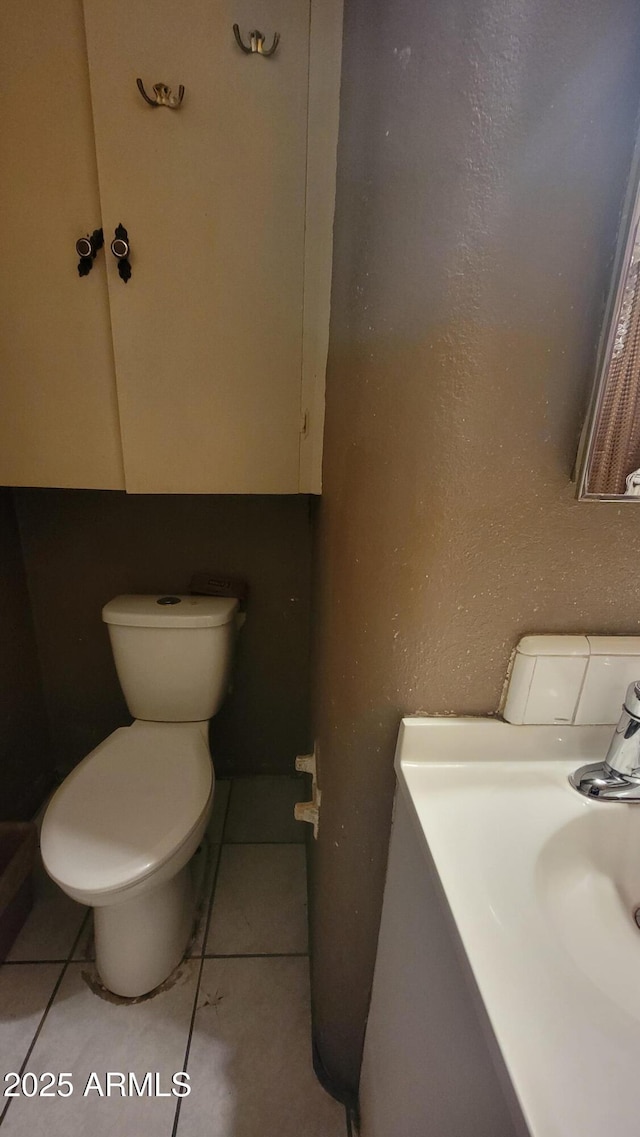 bathroom with sink, tile patterned floors, and toilet