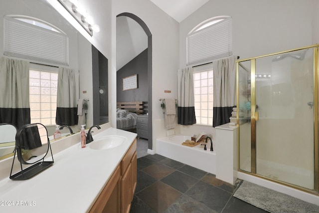 bathroom with a healthy amount of sunlight, independent shower and bath, high vaulted ceiling, and vanity