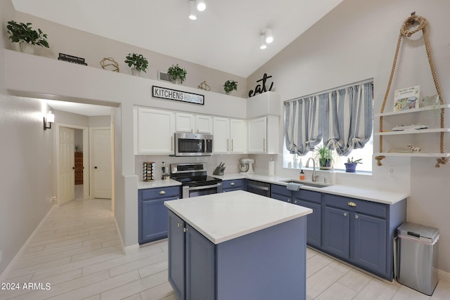 kitchen featuring blue cabinets, sink, a center island, stainless steel appliances, and white cabinets