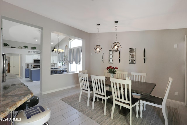 dining area featuring vaulted ceiling and a notable chandelier