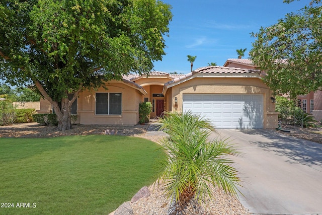 mediterranean / spanish-style home featuring a garage and a front yard