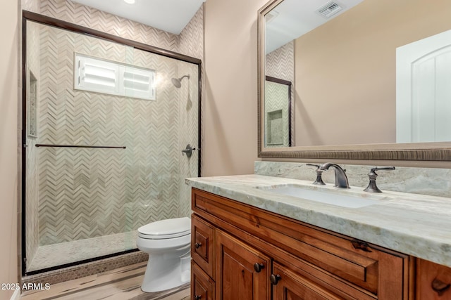 bathroom featuring vanity, toilet, and tiled shower