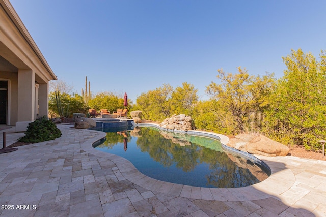 view of pool featuring a patio area and an in ground hot tub