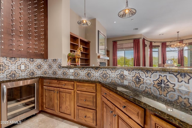 kitchen with light tile patterned floors, wine cooler, tasteful backsplash, decorative light fixtures, and dark stone counters