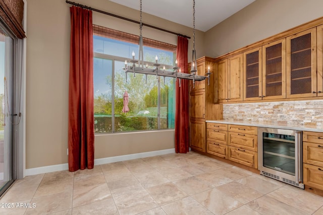 kitchen with a notable chandelier, decorative light fixtures, beverage cooler, and backsplash