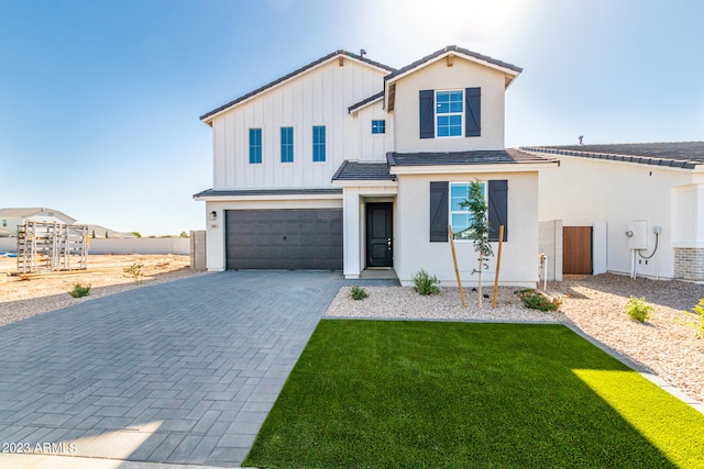 view of front of property featuring a garage and a front lawn