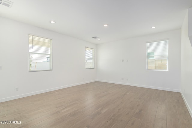 spare room featuring light hardwood / wood-style floors and plenty of natural light