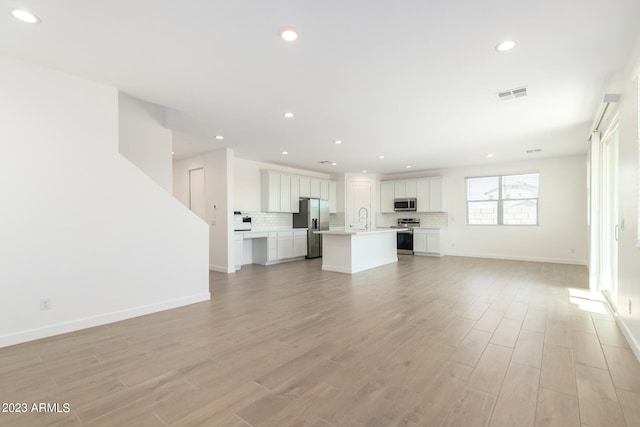 unfurnished living room with light hardwood / wood-style flooring and sink