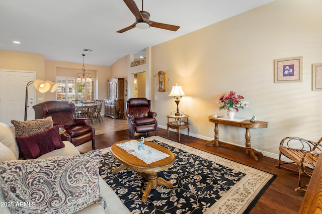 living room with ceiling fan with notable chandelier and dark hardwood / wood-style flooring