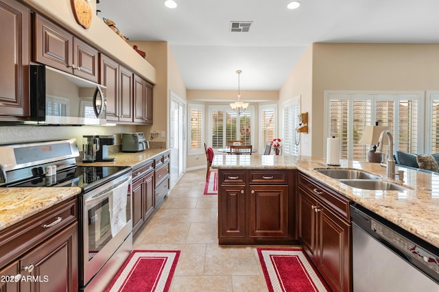 kitchen featuring lofted ceiling, an inviting chandelier, sink, appliances with stainless steel finishes, and decorative light fixtures