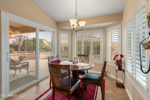 tiled dining space with lofted ceiling and an inviting chandelier