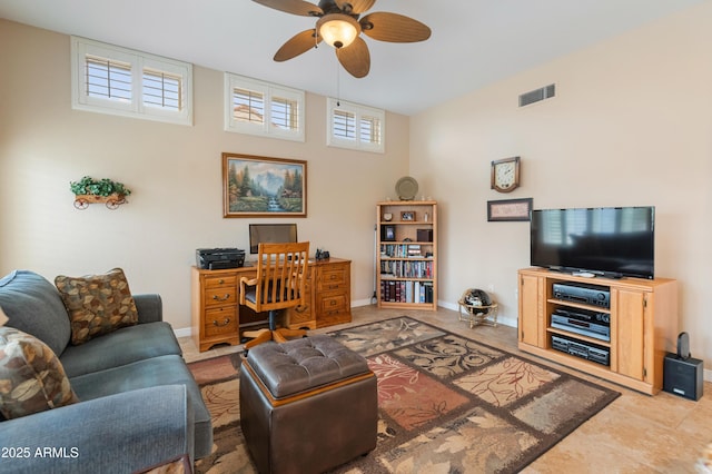 tiled living room with a wealth of natural light and ceiling fan