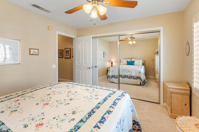 bedroom with multiple windows, ceiling fan, a closet, and light colored carpet