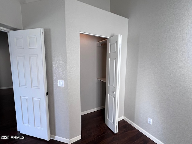 unfurnished bedroom featuring dark wood finished floors and baseboards