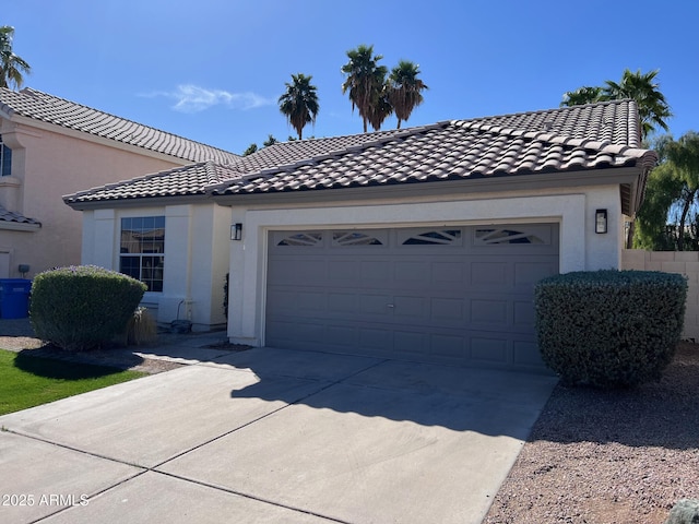 view of front facade featuring stucco siding, concrete driveway, an attached garage, and a tile roof