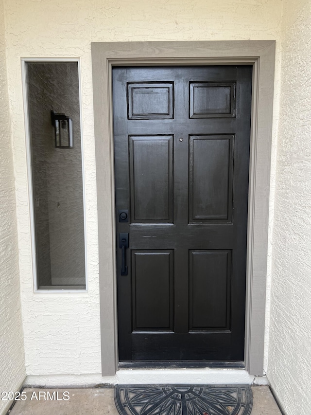 view of exterior entry featuring stucco siding