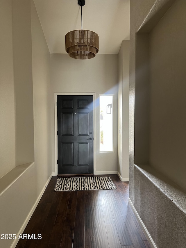 foyer entrance featuring dark wood finished floors and baseboards