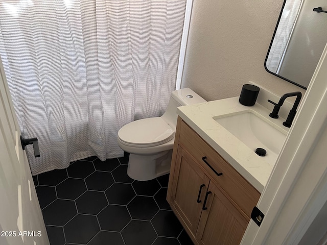 bathroom featuring tile patterned flooring, curtained shower, toilet, a textured wall, and vanity