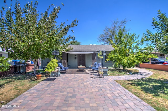 view of front facade featuring a front lawn and a patio area