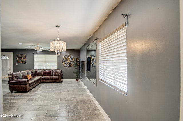 living room with ceiling fan with notable chandelier