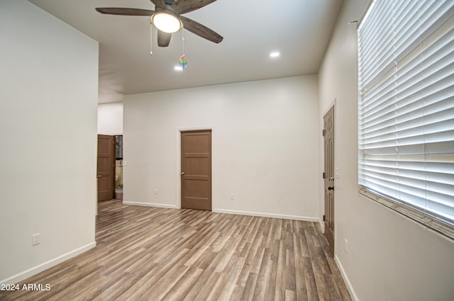 spare room with ceiling fan and light wood-type flooring