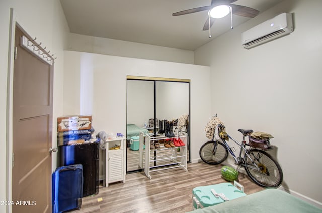 misc room featuring ceiling fan, hardwood / wood-style flooring, and a wall mounted AC