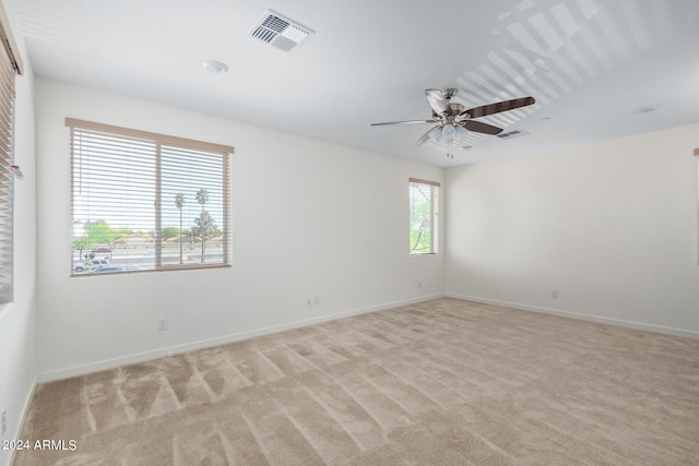 carpeted spare room featuring ceiling fan