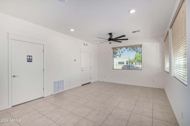 tiled spare room with ceiling fan