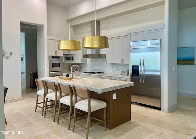 10821 E Troon N Dr, Scottsdale, AZ 85262 - kitchen with built in appliances, light countertops, backsplash, a high ceiling, and a breakfast bar