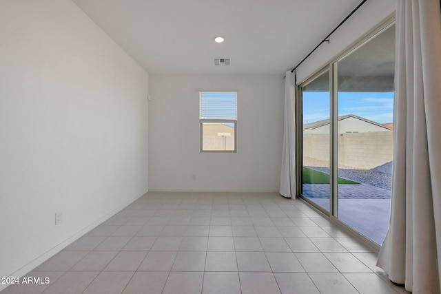 empty room featuring a healthy amount of sunlight and light tile patterned flooring