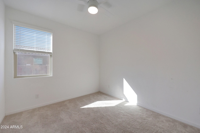 spare room featuring ceiling fan and light carpet