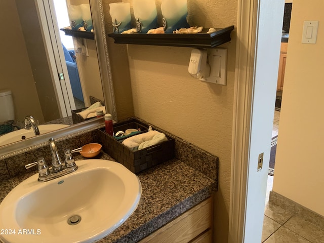 bathroom featuring tile patterned flooring, vanity, and toilet