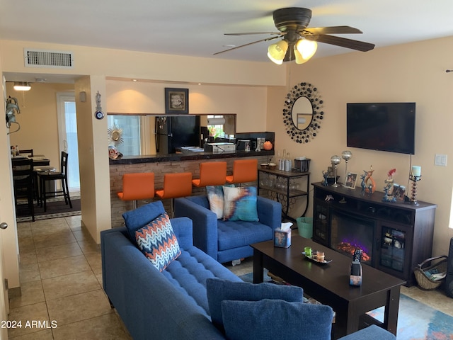 tiled living room with ceiling fan