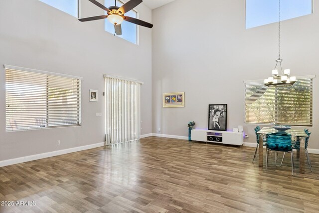 46141 W Rainbow Dr, Maricopa, AZ 85139 - living area featuring a towering ceiling, a chandelier, a ceiling fan, and wood finished floors
